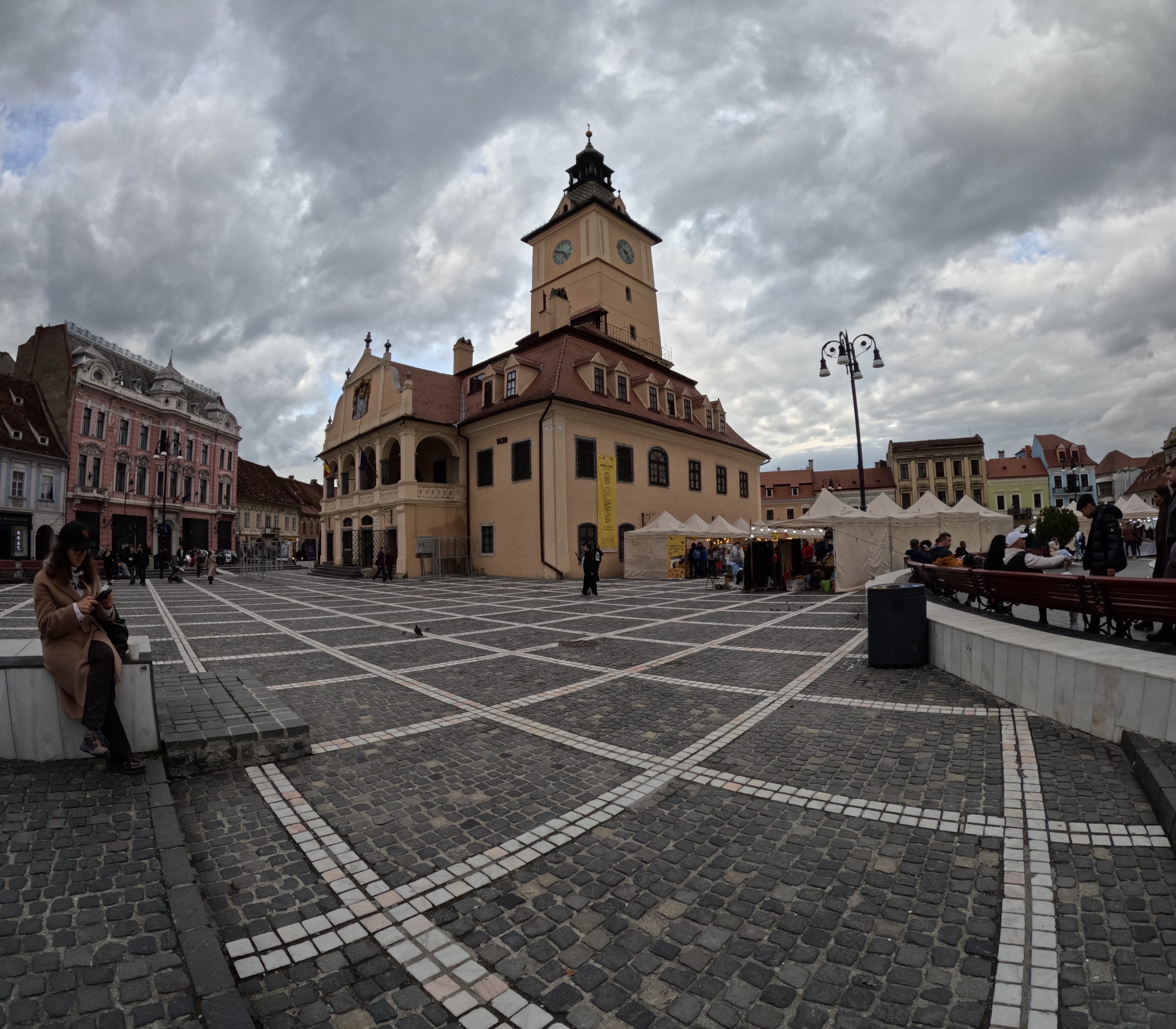 Brașovul este unul dintre cele mai frumoase orașe din România, un loc unde istoria și muntele se întâlnesc la fiecare colț de stradă. Fondat în secolul al XIII-lea de coloniști sași, orașul a purtat mult timp numele de Kronstadt („Orașul Coroanei”) și a fost un important centru comercial al Transilvaniei, datorită poziției sale strategice între Țara Românească și Europa Centrală. Zidurile cetății, turnurile de apărare și Poarta Ecaterinei amintesc de epoca medievală, când Brașovul era protejat și prosper. În inima orașului, Piața Sfatului rămâne unul dintre cele mai pitorești locuri din țară, dominată de Biserica Neagră, cel mai mare edificiu gotic din Europa de Est. Astăzi, Brașovul își păstrează farmecul vechi, dar are și o energie modernă – o combinație de istorie, cultură și natură care îl face irezistibil pentru turiști și localnici deopotrivă.